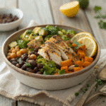 Rustic bowl of dense bean salad with shredded grilled chicken, roasted Brussels sprouts, black beans, chickpeas, carrots, and fresh herbs