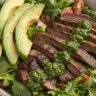 Chimichurri steak salad with avocado in a rustic bowl