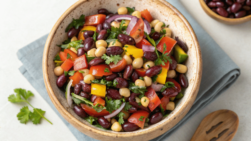 No-lettuce bean salad with kidney beans, chickpeas, bell peppers, and fresh herbs in a rustic bowl