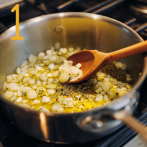 Onions and garlic sautéing in olive oil in a pot with wooden spoon