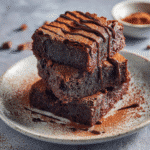 Served gluten-free brownies on a plate with chocolate drizzle