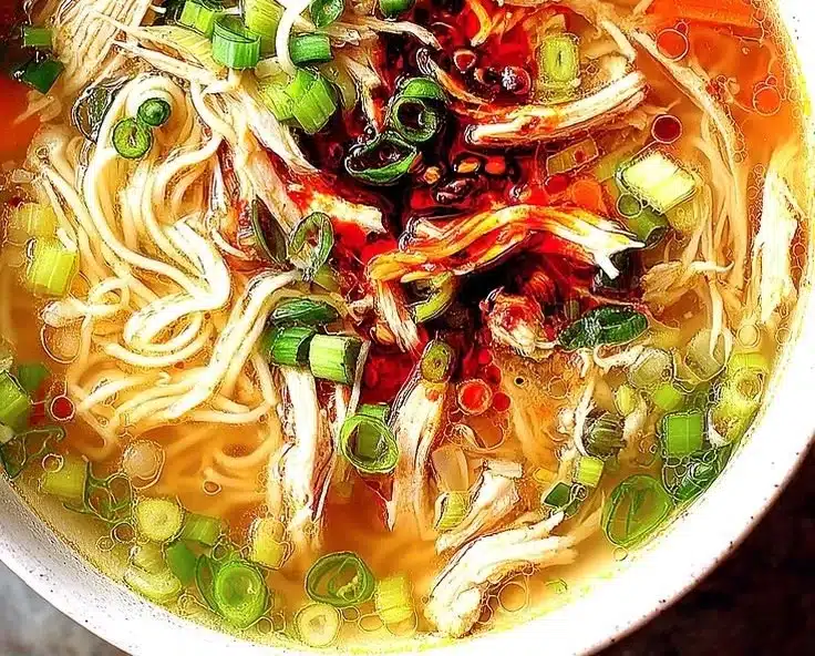 Bowl of aromatic Ginger Garlic Chicken Noodle Soup with fresh herbs