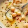 Bowl of homemade Garlic Chickpea Soup topped with herbs and spices.