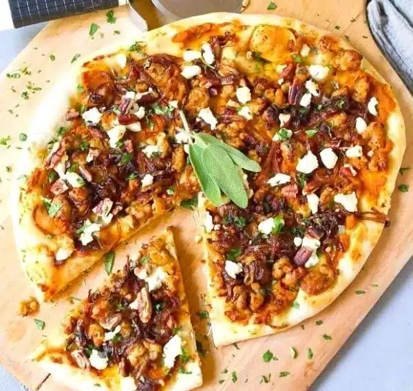 Delicious pumpkin pizza topped with slices of Italian chicken sausage