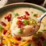 Bowl of cheesy potato soup topped with crispy hash browns