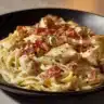 Creamy Chicken Bacon Ranch Pasta topped with crispy bacon and herbs