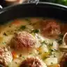 A bowl of cozy Swedish meatball soup with herbs and spices.