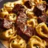 Delicious cracked garlic steak tortellini in creamy sauce served on a plate