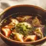 Bowl of homemade Potsticker Soup with dumplings and fresh vegetables