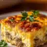 Sausage and Egg Casserole served in a baking dish with fresh herbs