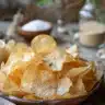 Bowl of crispy homemade cottage cheese chips on a wooden table