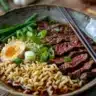 Delicious bowl of beef ramen noodles topped with herbs and veggies
