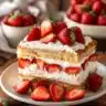 Delicious easy strawberry cake topped with fresh strawberries and whipped cream