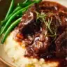 Delicious oven short ribs served with vegetables and herbs on a plate