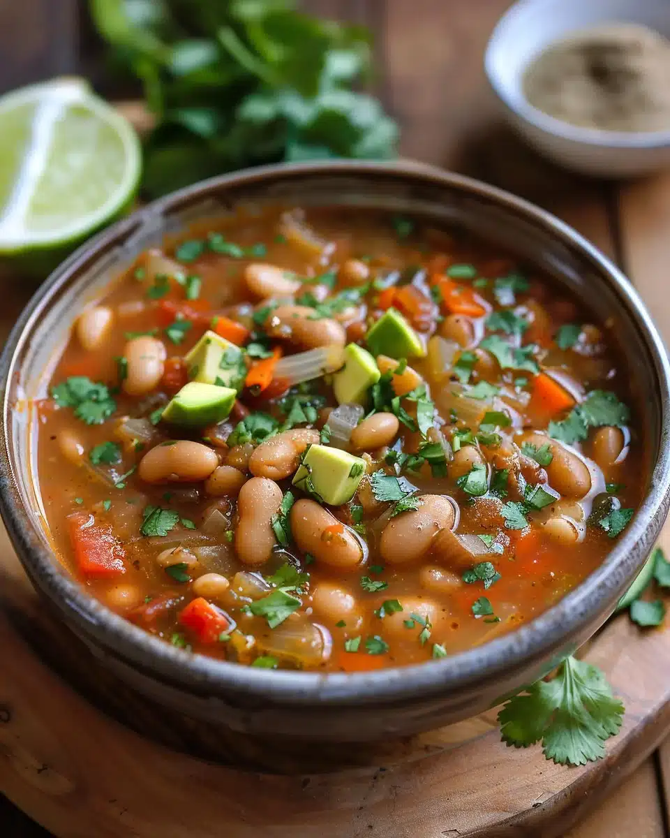 A warm bowl of homemade Pinto Bean Soup garnished with fresh herbs
