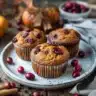 Pumpkin muffins with dried cranberries on a rustic wooden table