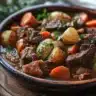 Bowl of delicious slow cooker beef stew with vegetables and herbs