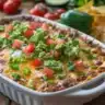 Delicious Taco Dip with Refried Beans served in a colorful bowl