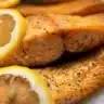 Delicious grilled trout served on a plate with herbs and lemon slices