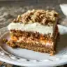 Slice of cream cheese carrot coffee cake with frosting on a white plate