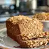 Freshly baked no-knead honey oat bread loaf on a wooden table.