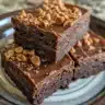 Delicious Peanut Butter Cup Brownies topped with melted chocolate and peanut butter cups.