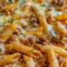 Delicious Cheesy Beef Penne pasta topped with melted cheese and beef sauce