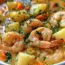 A bowl of creamy shrimp chowder topped with herbs and garnishes