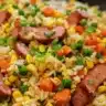 A delicious plate of easy hot dog fried rice garnished with green onions