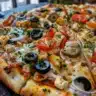 Delicious Greek pizza with olives, feta cheese, and fresh vegetables