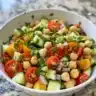 Healthy chickpea salad with fresh vegetables and herbs.