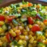Healthy corn salad with fresh vegetables and dressing showcased in a bowl