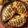 Herb grilled chicken breast garnished with fresh herbs and spices.