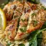 Bowl of Lemon Chicken Orzo with Spinach, garnished with herbs.