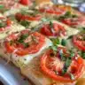 Flatbread topped with Margherita Pizza ingredients - tomatoes, mozzarella, and basil.