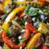 Mediterranean ground beef stir fry with colorful vegetables in a skillet