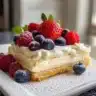 Delicious No Bake Berry Chantilly Cake topped with fresh berries and whipped cream