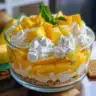 No Bake Mango Cheesecake Cups topped with mango slices and mint leaves