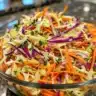 Bowl of zesty coleslaw with colorful vegetables and dressing