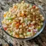 Bowl of creamy Amish Macaroni Salad with vegetables and pasta