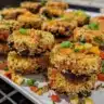 Delicious homemade black bean burgers on a plate with fresh vegetables.