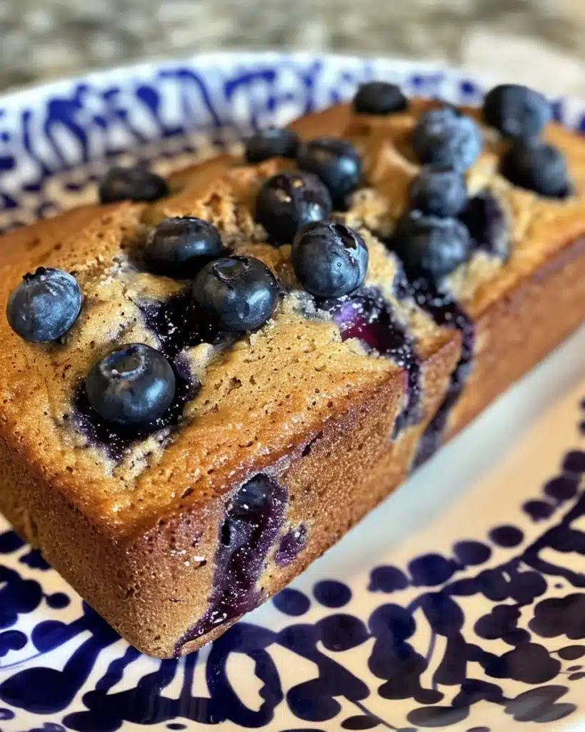 Loaf of homemade blueberry muffin bread with fresh blueberries