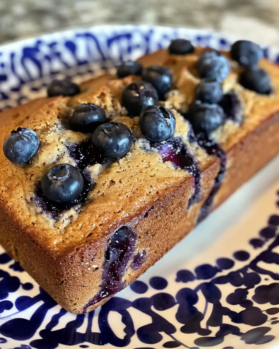Loaf of homemade blueberry muffin bread with fresh blueberries