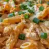 Delicious Buffalo Chicken Baked Ziti topped with cheese and spicy sauce