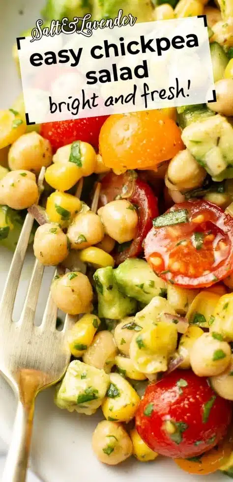 Colorful chickpea salad with vegetables and herbs in a bowl.