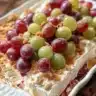 Creamy grape salad with a rich dressing and fresh grapes in a bowl.