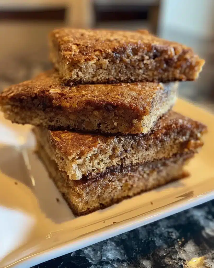 Easiest applesauce cake topped with frosting on a wooden table.
