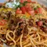 A delicious serving of easy taco spaghetti topped with cheese and cilantro.