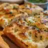 Freshly baked Garlic Knots topped with herbs and served with marinara sauce