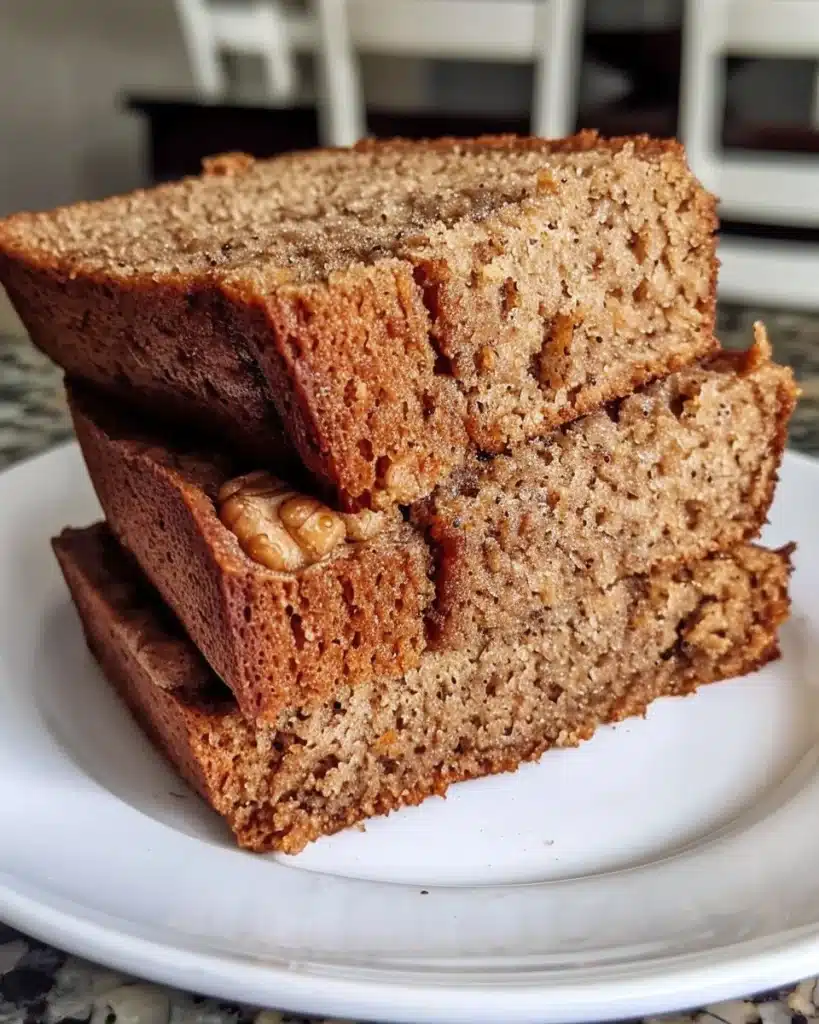 Healthy whole wheat banana bread sliced on a wooden board.